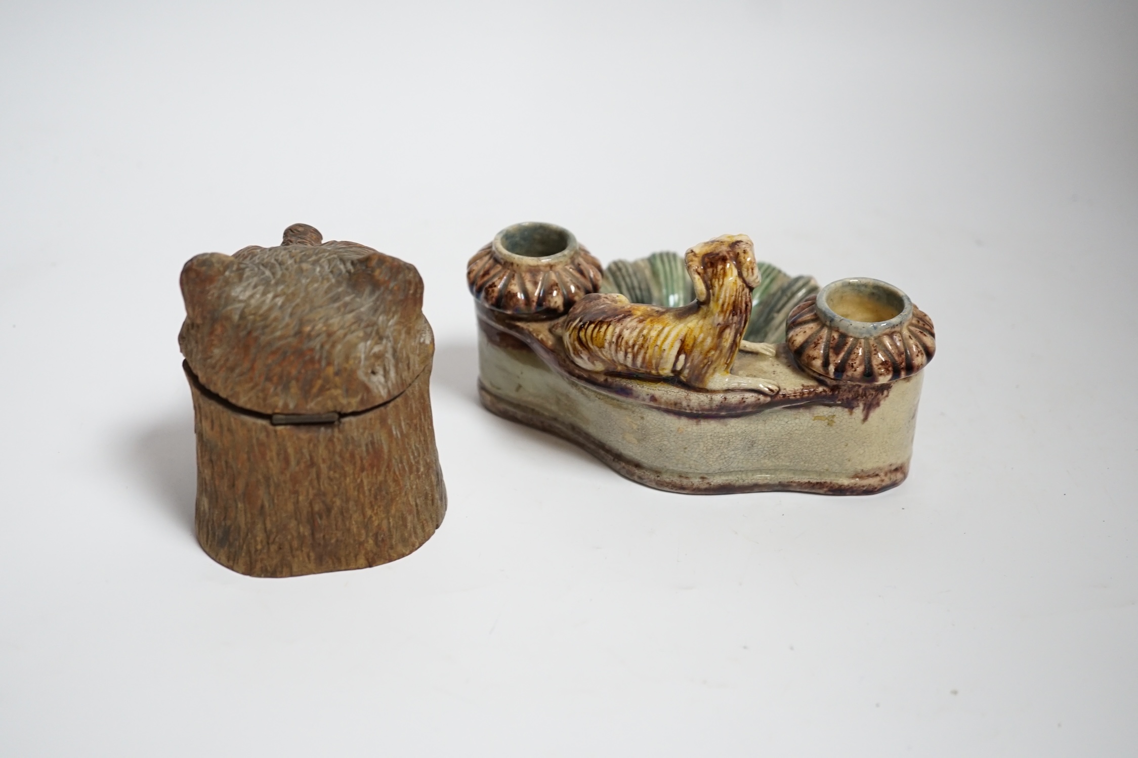 A Black Forest carved bear inkwell and a majolica inkwell surmounted with a dog, largest 14cm wide